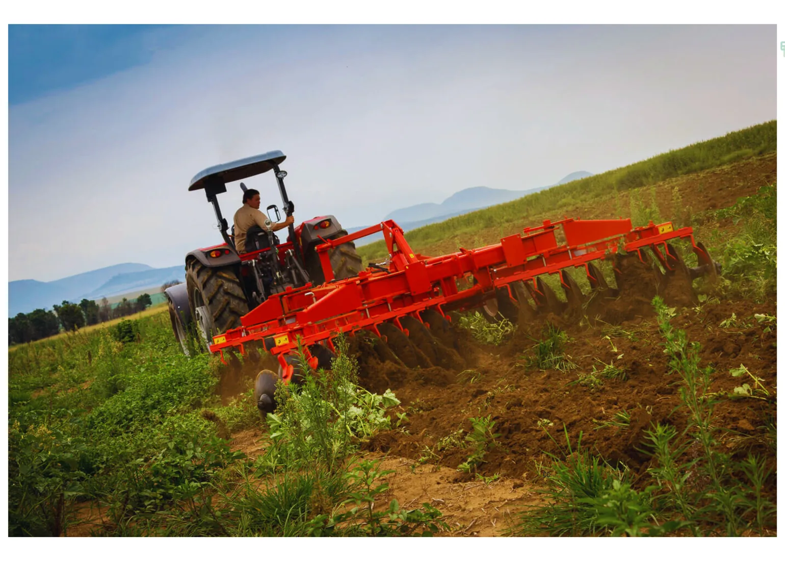 Disc harrow working behind a tractor in field conditions